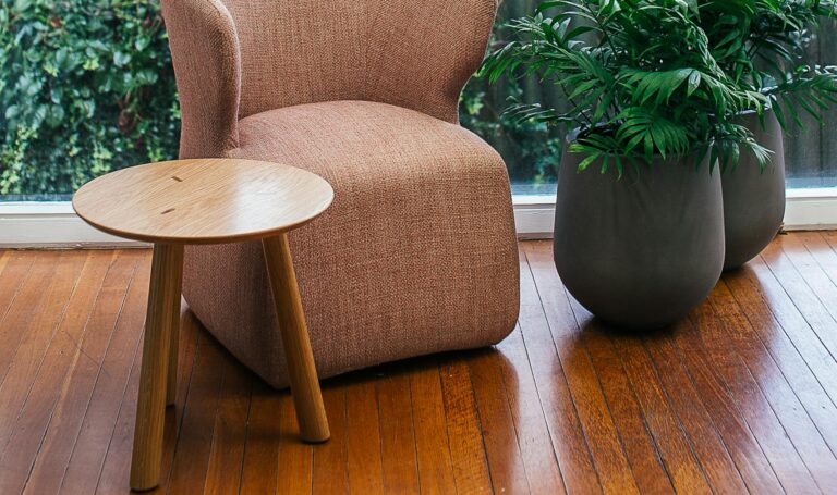 Potted plants in room near window and armchair, wooden flooring