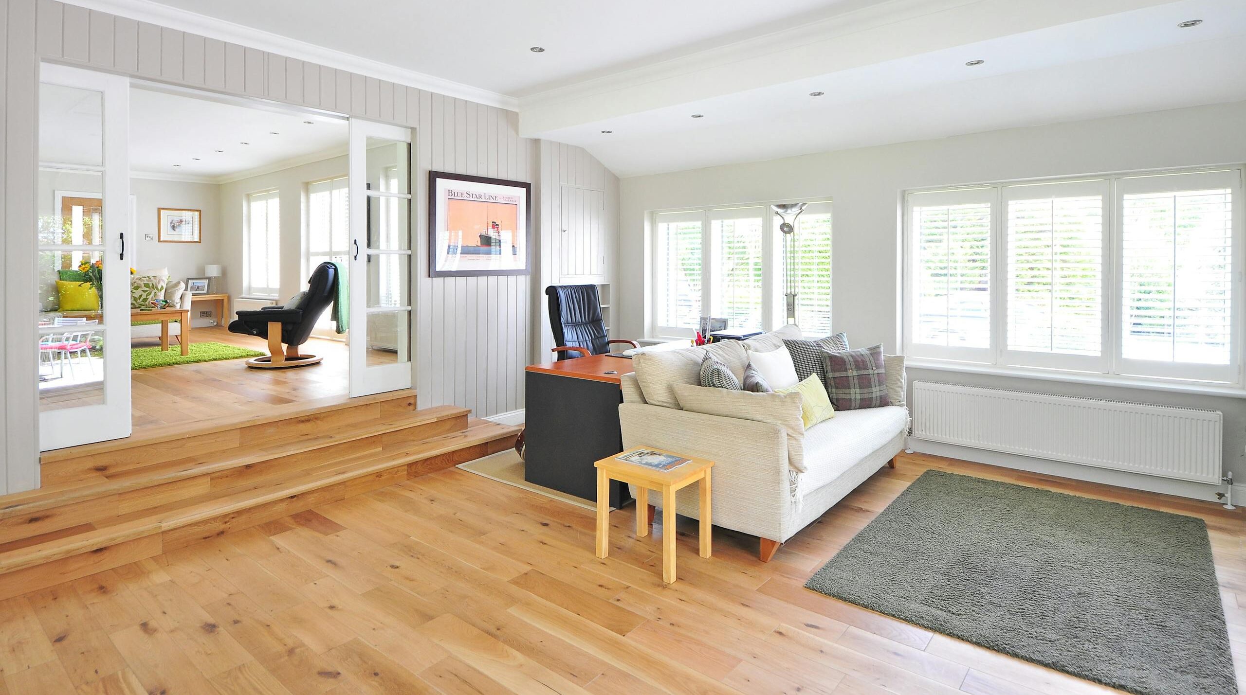 White Couch Near Black Mat upon engineered wooden flooring