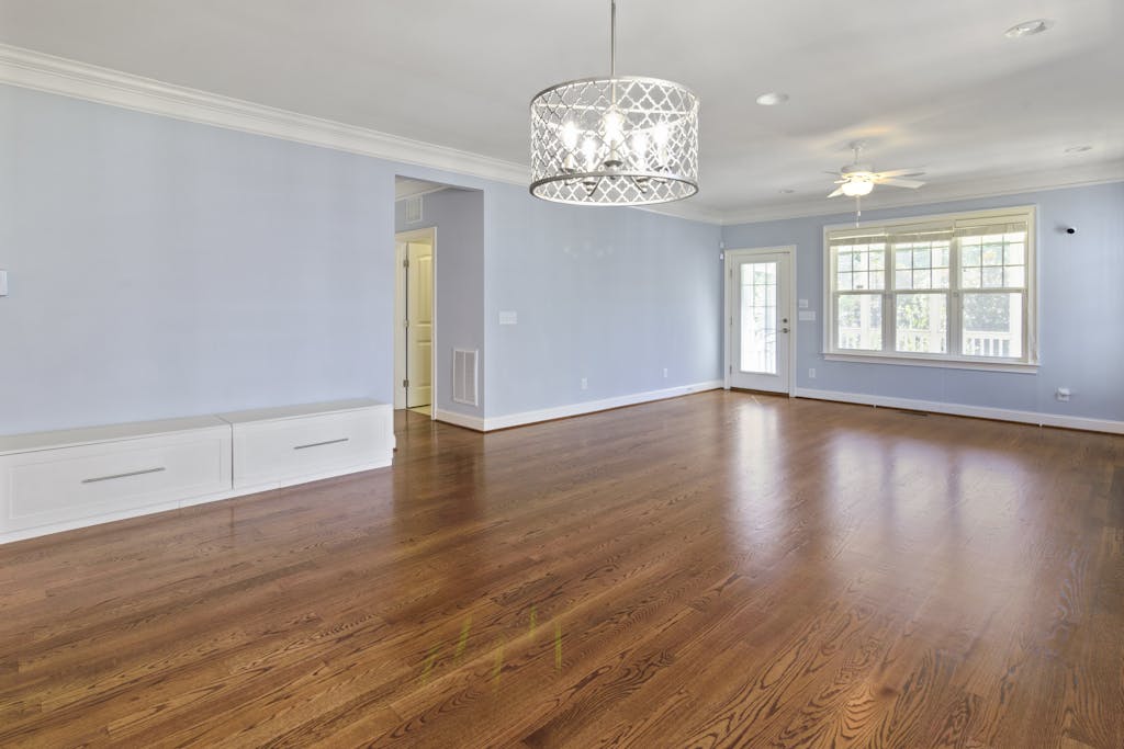 Empty Room with Blue Walls and Silver Chandelier, hardwood flooring