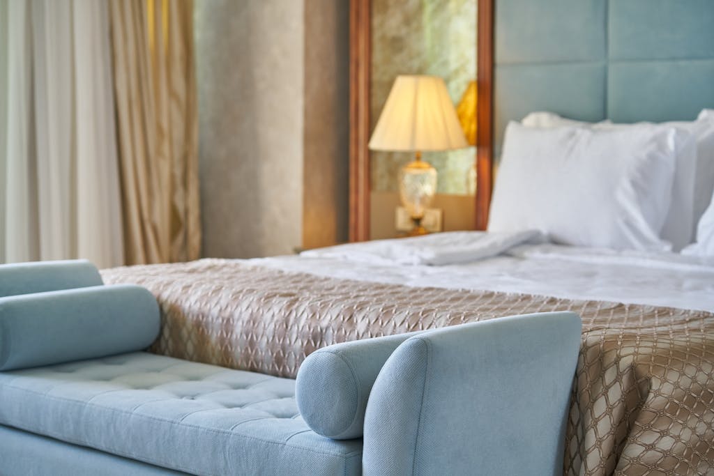 Elegant bedroom interior featuring plush bed and seating with cozy ambiance lighting. Which Bed is Best for Your Bedroom? Complete Guide